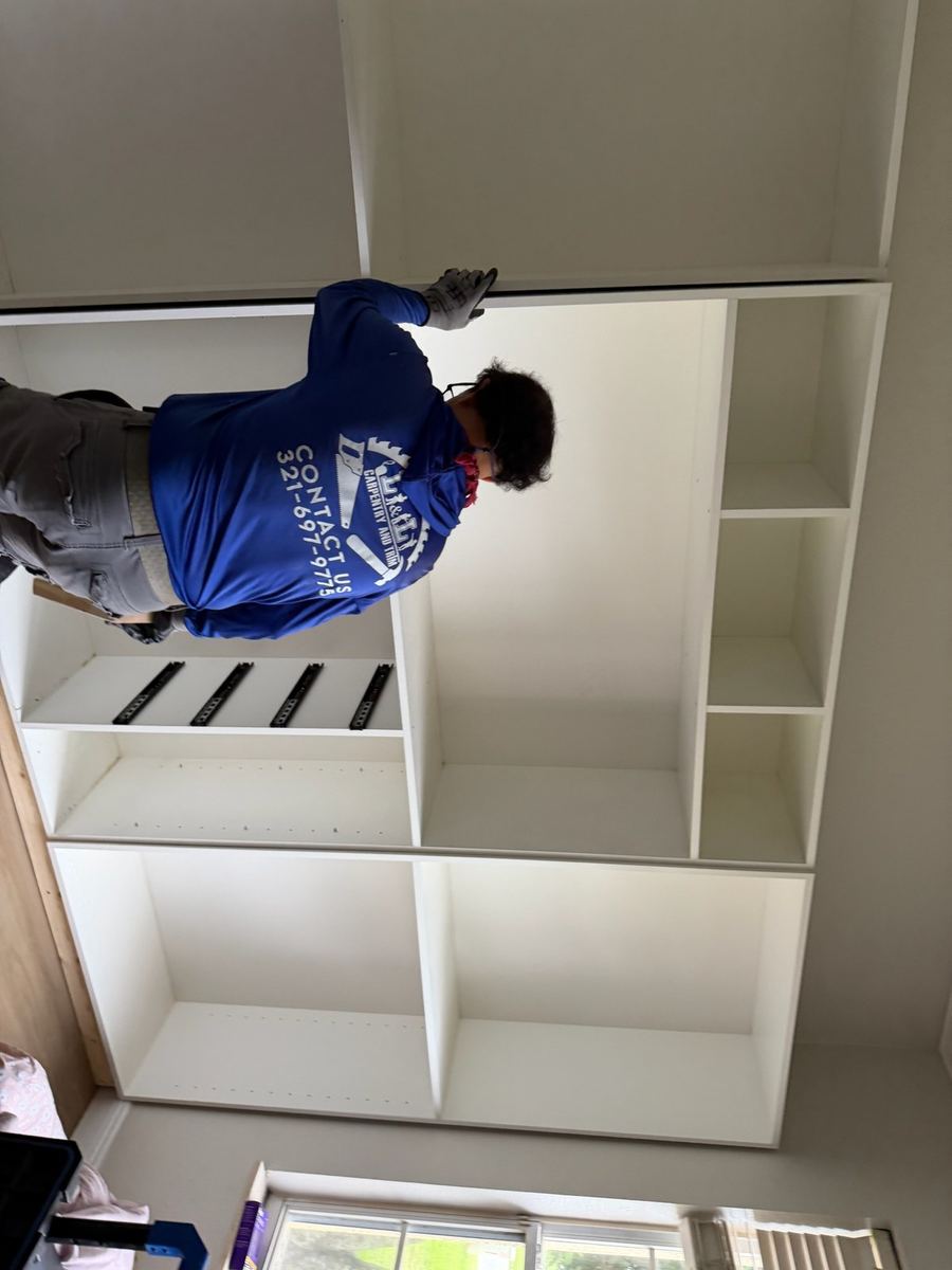 A Karino installer fitting shelving during a closet installation