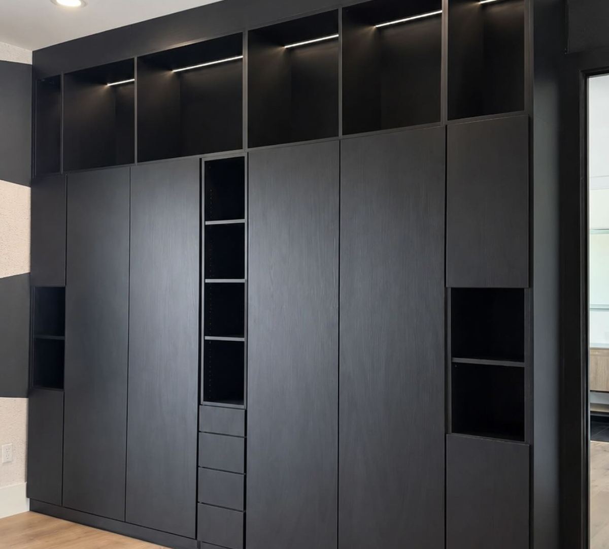 Black double murphy bed system built into full height cabinetry