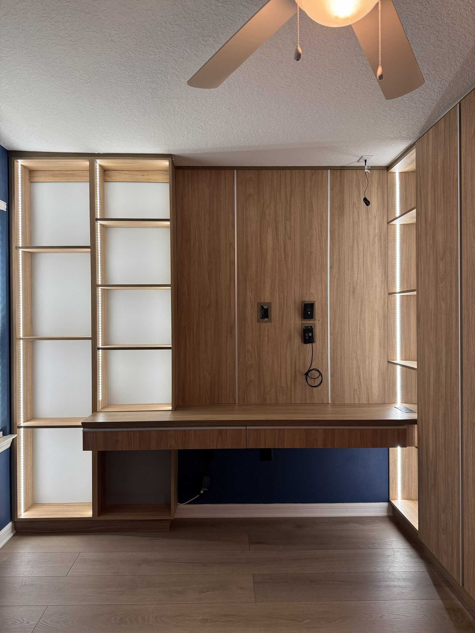 Home office built-in with floating desk and LED shelving