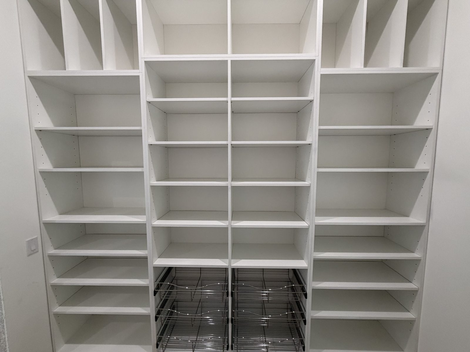 Tall white pantry with pull-out wire baskets