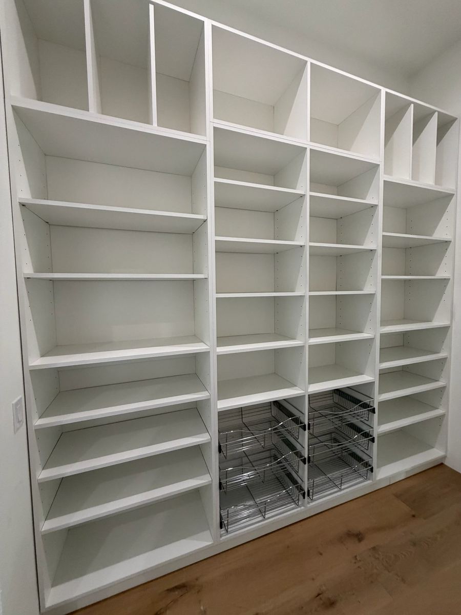 White shoe shelving wall with wire basket drawers