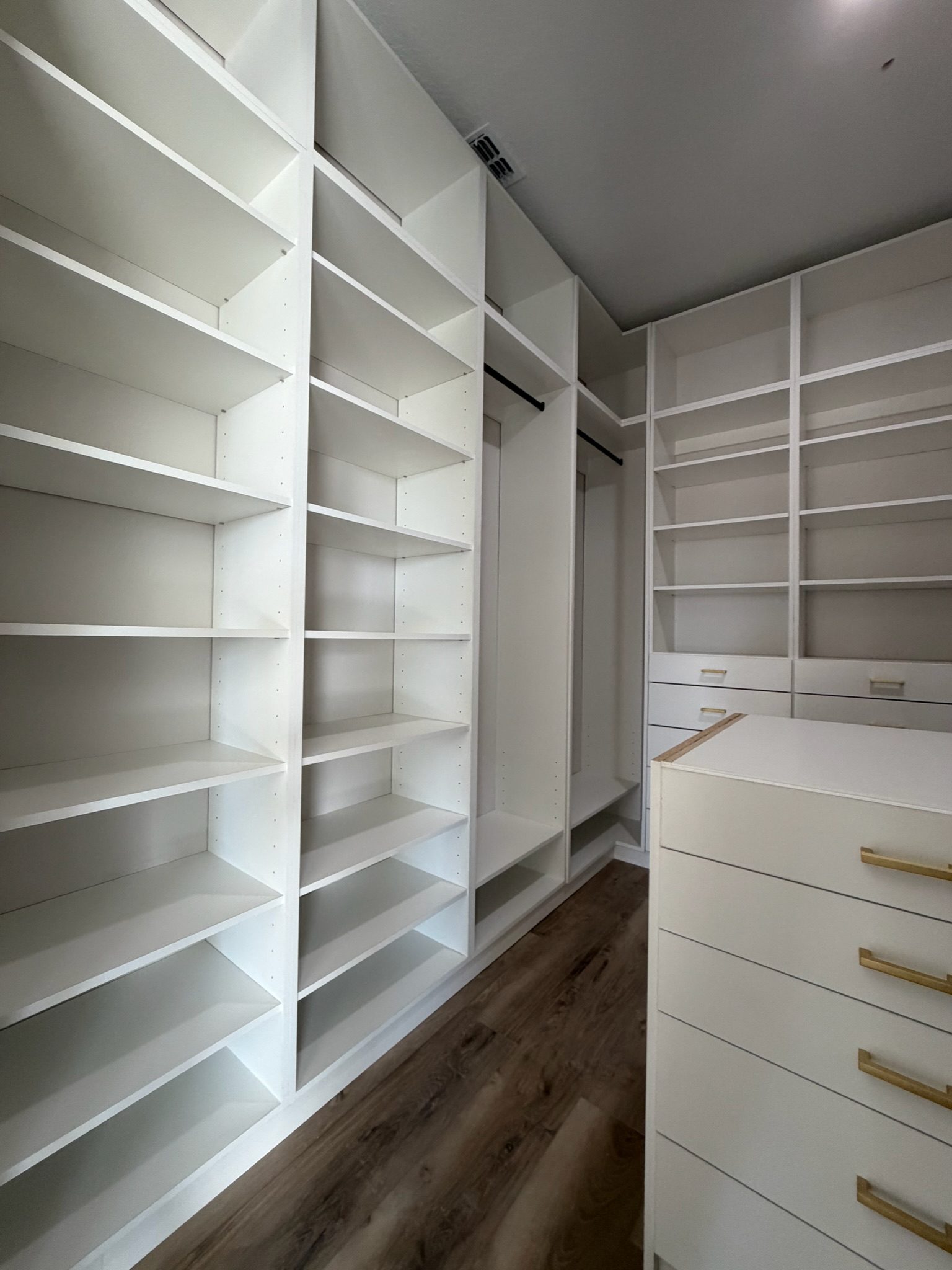 White custom walk-in closet with brass hardware installed by Karino Custom Closets, serving Dr. Phillips FL