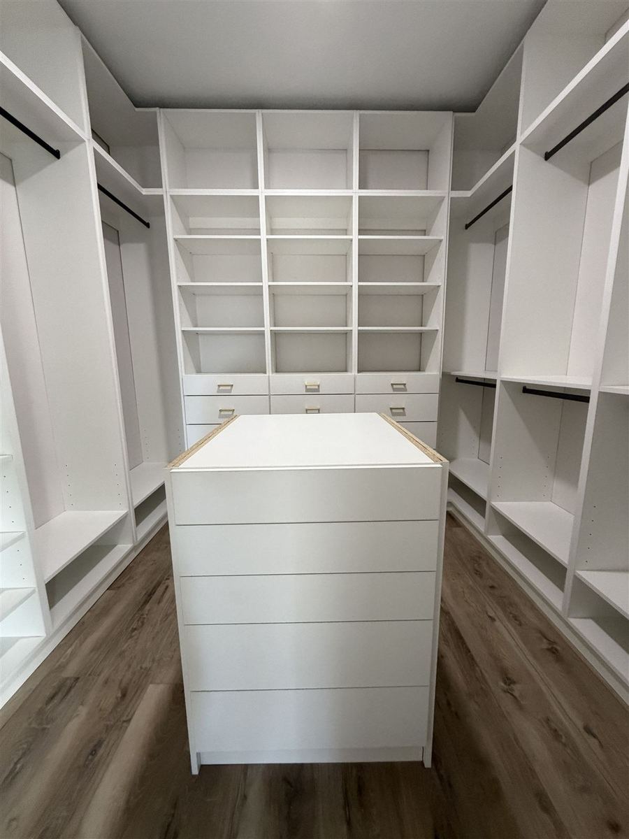 White walk-in closet with a central island dresser
