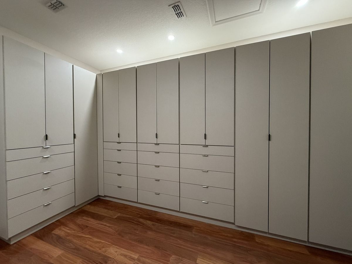 Greige built-in wardrobe wall with a long drawer bank