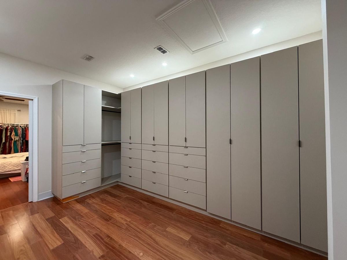 Greige wardrobe wall opening onto a hanging closet